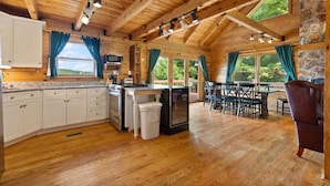 A log cabin with a kitchen, dining area, and large windows. - Large Luxury Log Cabin, Sleeps-13, Spectacular view! Loaded with ammenities! (Rogers)