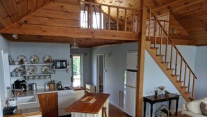 Eine geräumige Küche mit Holzausstattung, einem Essbereich und einer Treppe zu einer oberen Ebene.