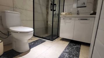 Appartement | Badkamer | Een douche, een haardroger, handdoeken