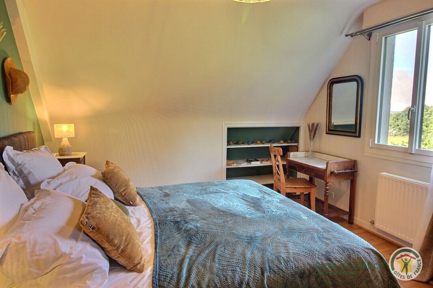 Une chambre à coucher comprenant un lit, un bureau, une chaise, une fenêtre et une étagère ornée d’objets décoratifs.