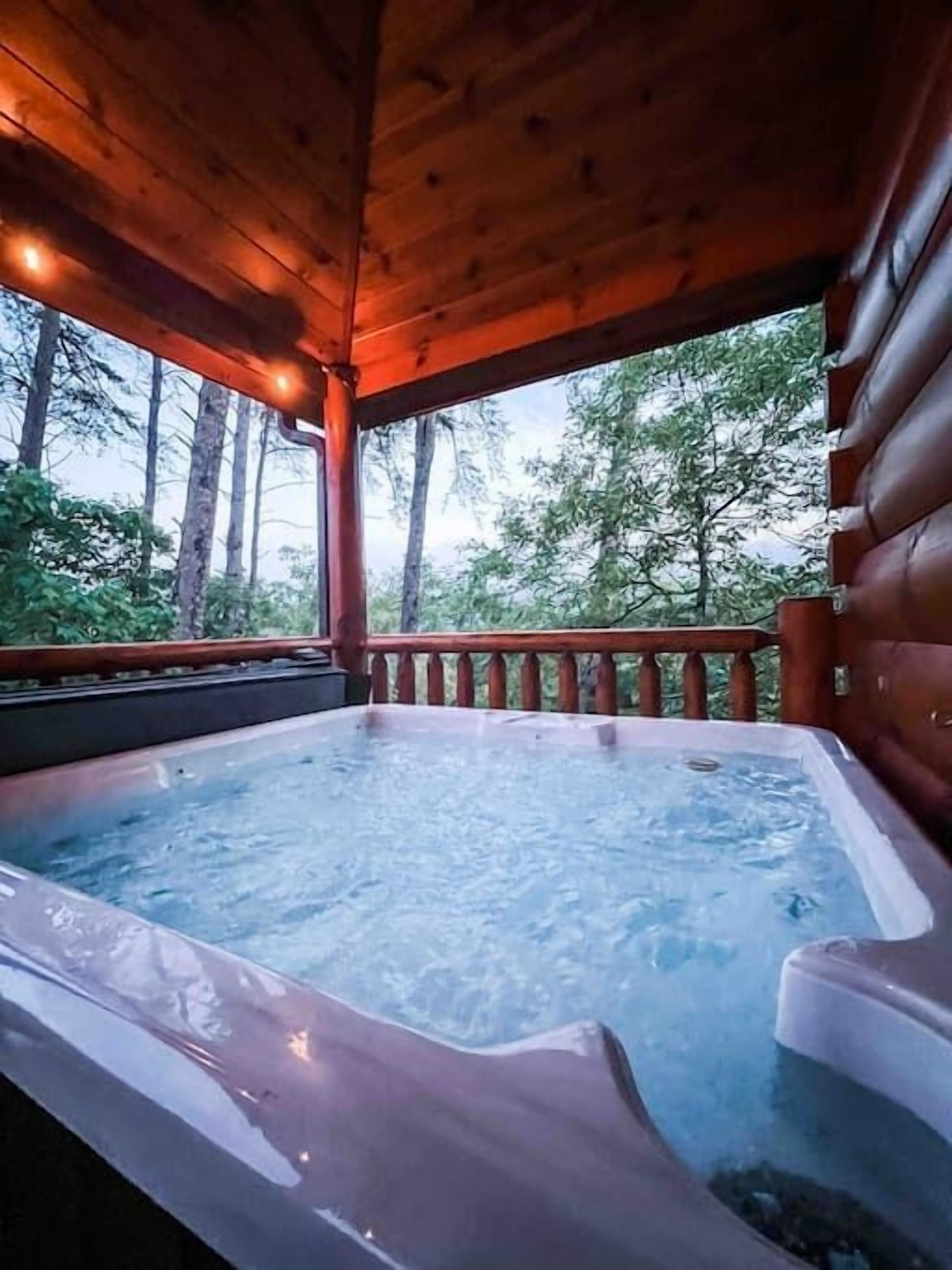 Un jacuzzi en una terraza de madera con vistas a árboles.