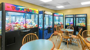 A room with multiple claw machines labeled 'Toy House' filled with plush toys. There are wooden chairs and a small table in the center. - Two Bedroom Condo, Pigeon Forge, TN (2891079) (Pigeon Forge)
