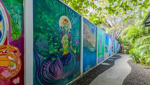 A pathway lined with colorful murals. - Iluminar Beachfront Suite (Nosara)