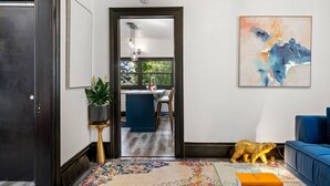 Una sala de estar moderna con un sofá azul, una escultura dorada decorativa de un animal y una alfombra colorida.