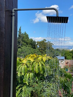 A garden with a water feature, including a metal pipe and a rectangular water spout with multiple streams. - Mitre "The indulgent Experience" (Mendoza)