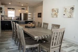 Enjoy meals in the spacious kitchen and dining area, featuring a central island and long dining table.