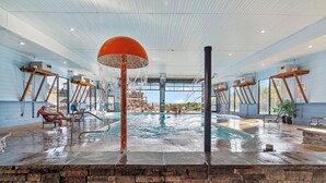 An indoor swimming pool with a large water fountain, stone walls, and a clear view of the sky. - Lakeview Home: Private Hot tub and Sauna (Branson)