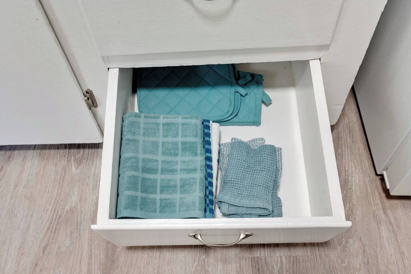 Un tiroir contenant des serviettes soigneusement pliées et une couverture matelassée.