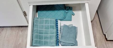 Un tiroir contenant des serviettes soigneusement pliées et une couverture matelassée.