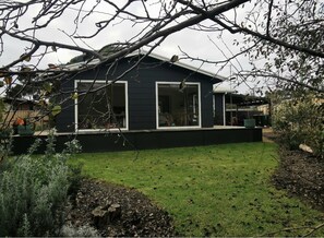 Relax in an outdoor space surrounded by lush greenery and a well-manicured lawn.