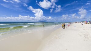 Una playa con cielos despejados y aguas tranquilas.