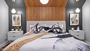 A modern bedroom with a large bed, two bedside tables, and a wooden slatted ceiling. - 3min to Aquarium | Secret Game Room | 3 King Beds (Chattanooga)