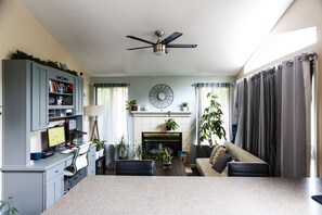 Cozy living room with a fireplace, sofa, chairs, desk, and bookshelf.