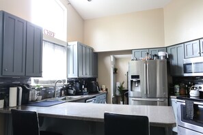 Enjoy cooking in this well-equipped kitchen with a central island, coffee maker, and stainless steel appliances.