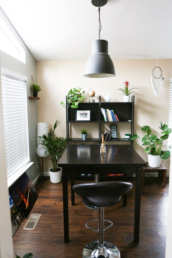 Enjoy meals in this stylish dining area with a dark table, pendant light, and bookshelf.