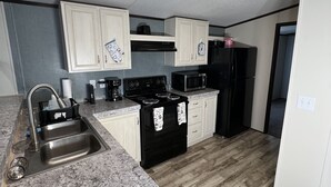 A modern kitchen with granite countertops, stainless steel appliances, and white cabinetry.