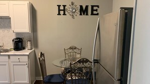 A kitchen with white cabinets, a coffee maker, a refrigerator, and a dining table with chairs. - EXPLORE & RELAX Heart of the city,NEAR EVERYTHING! (Buffalo)