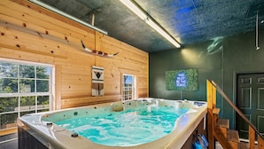A hot tub in a wooden cabin with a view of trees outside. - Private cabin with amenities ⭐️Location⭐️Spa Pool⭐️Hot tub⭐️Firepit⭐️Pets (Sevierville)