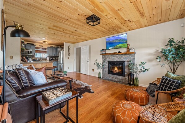 A spacious living room with a leather sofa, a fireplace, and a television. - Private cabin with amenities ⭐️Location⭐️Spa Pool⭐️Hot tub⭐️Firepit⭐️Pets (Sevierville)