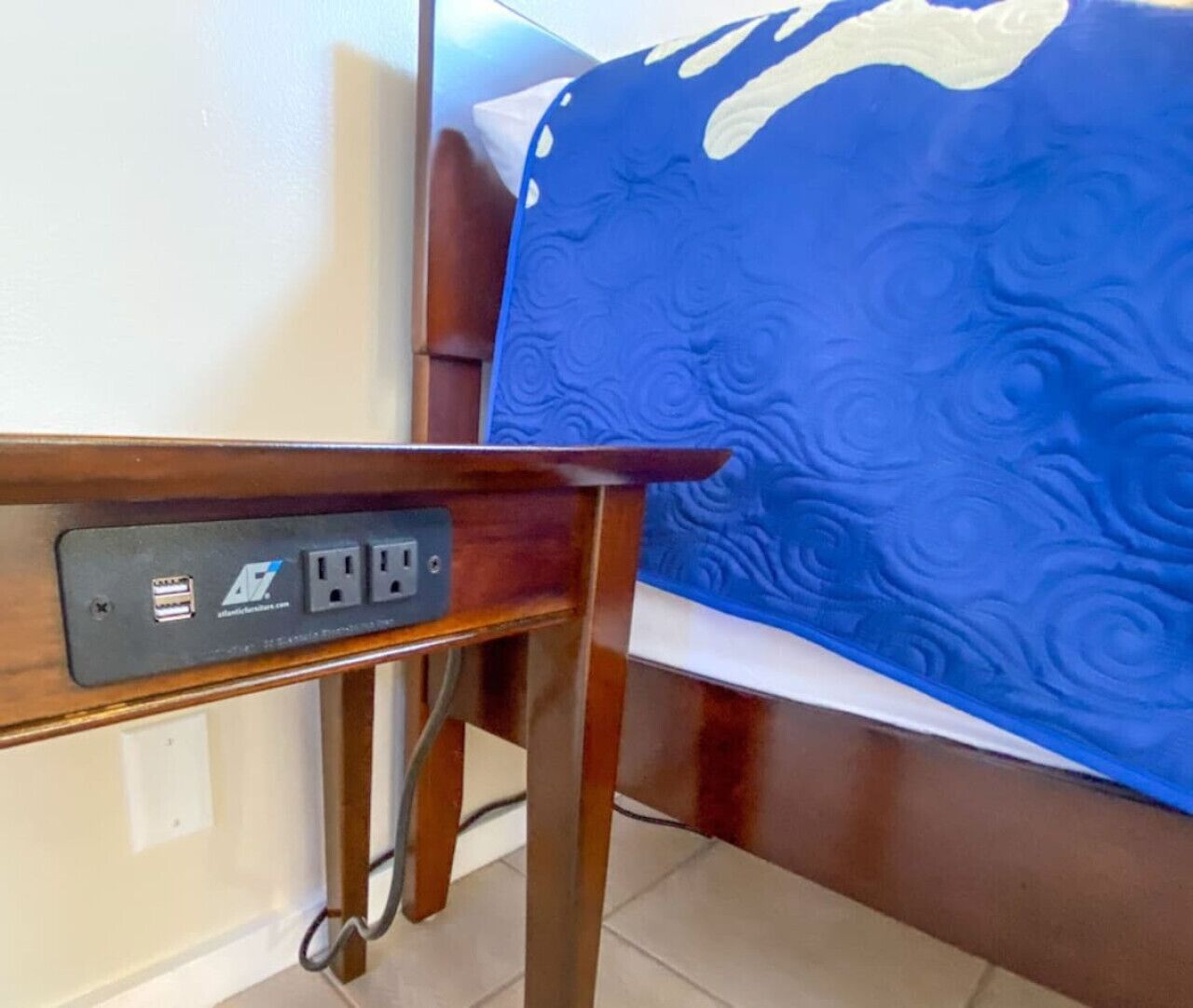 A wooden table with a power strip and a cable.