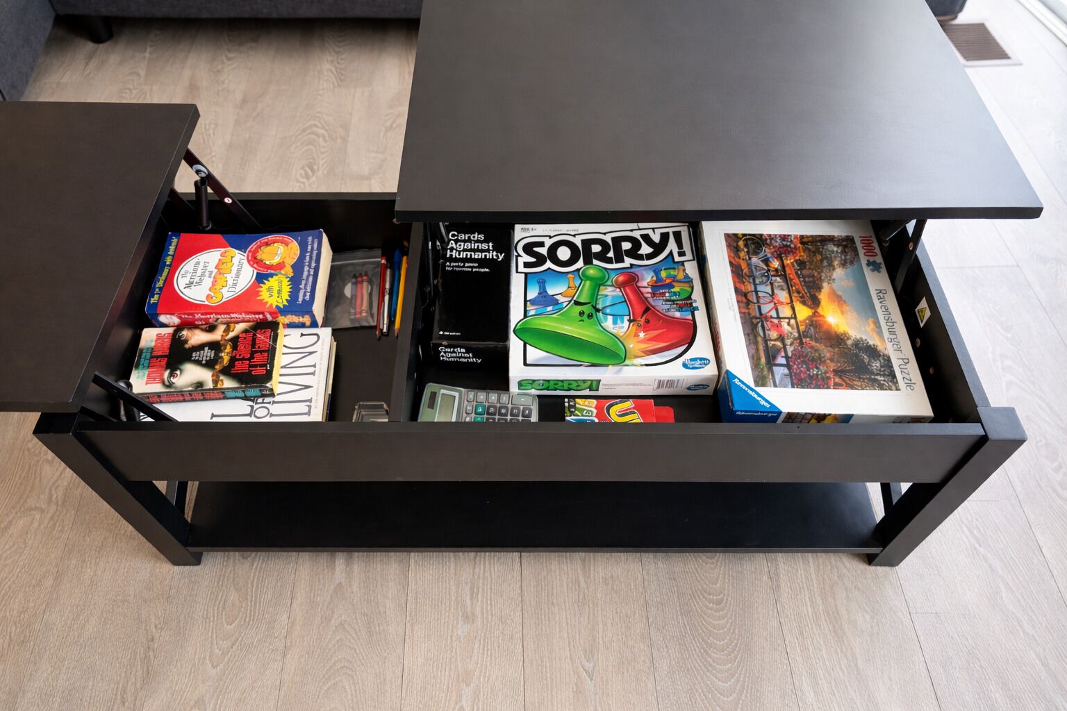 A drawer unit with various board games and magazines.
