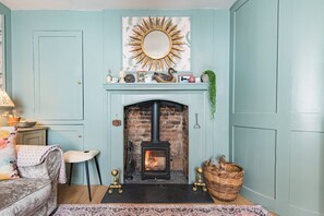 Una habitación con chimenea, un espejo encima y una alfombra estampada.
