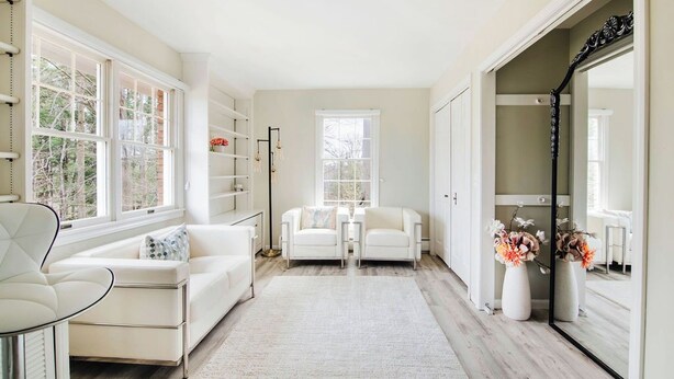 A spacious room with a white sofa, two armchairs, a small table, and a mirror. - Castle Farms wedding weekend, 7BR (Charlevoix)