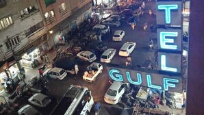 A busy street scene with a neon sign for the Hotel Gulf. - Gulf Hotel (Karachi)