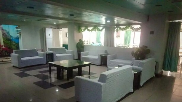 A lobby with white sofas, a coffee table, and a checkered floor. - Gulf Hotel (Karachi)