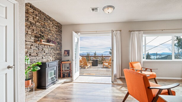 Una habitación con pared de piedra, chimenea, piso de madera y vistas al exterior.