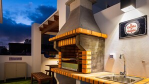 An outdoor kitchen with a brick oven, a sink, and a welcome sign.
