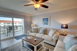Relax in this stylish living room with a sofa, coffee table, and side table, plus a balcony with a view.