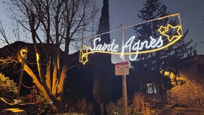 A sign with 'Sainte Agnes' illuminated in a star shape, surrounded by trees and a stone wall. - Charming, relaxing apartment (Sainte Agnès)