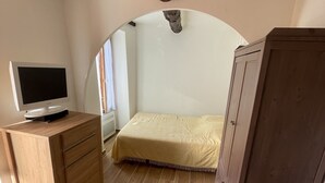 A bedroom with a bed, a wooden desk with a television, and a wardrobe. - Charming, relaxing apartment (Sainte Agnès)