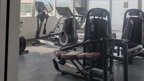 A gym with exercise equipment, large windows, and a view of the outdoors.
