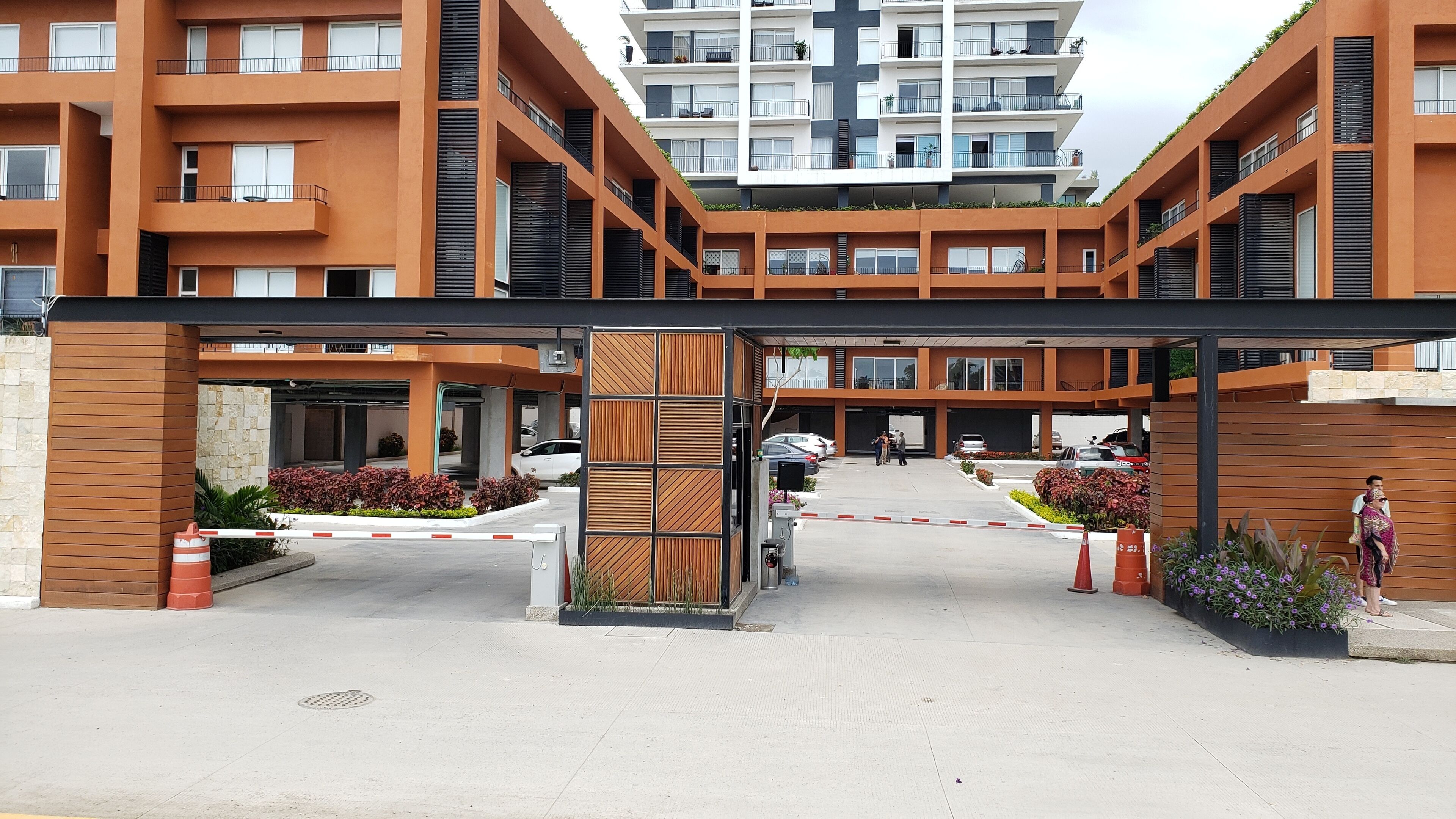 Un bâtiment moderne à plusieurs étages, doté d’une entrée abritée et d’un espace de stationnement.
