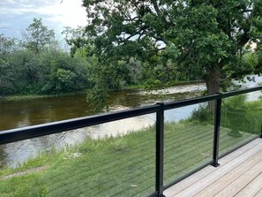 Eine Holterrasse mit Glasgeländer, mit Blick auf einen Fluss.