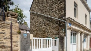 A stone building with a white gate and a number sign '34' on a post. - Les Tourelles by Interhome (Dinard)