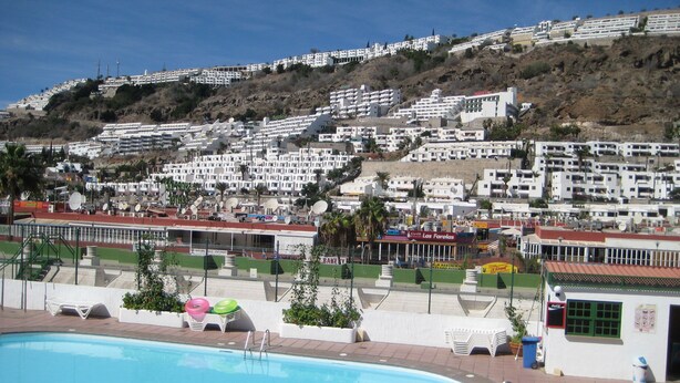 Una piscina con vista su una zona residenziale collinare.
