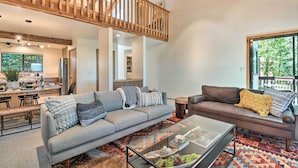 A spacious living area with a high wooden ceiling, a grey sofa, a brown sofa, and a glass coffee table. - Hike, Fish, & Relax: Family Arnold Cabin (Arnold)