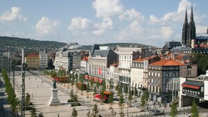 Paisagem urbana histórica com uma catedral imponente, uma praça ampla para pedestres e arquitetura europeia tradicional.