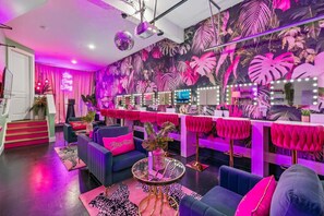 A vibrant room with a bar area, a disco ball, and a large mirror reflecting the room.