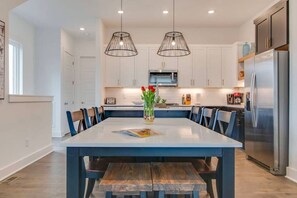 A modern kitchen with white cabinets, stainless steel appliances, and a central island with seating. - Good Vibes Only - Walkable to breweries, cafes, restaurants & close to Broadway (Nashville)