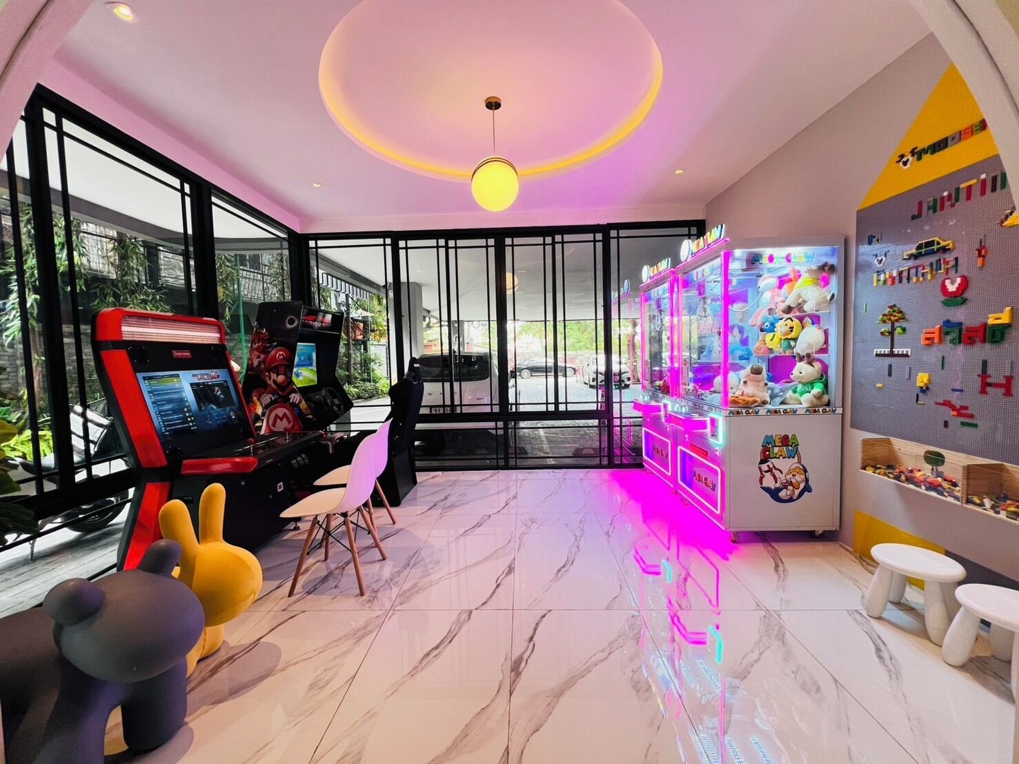 A gaming area with arcade machines, plush toys, and a wall with alphabet blocks.