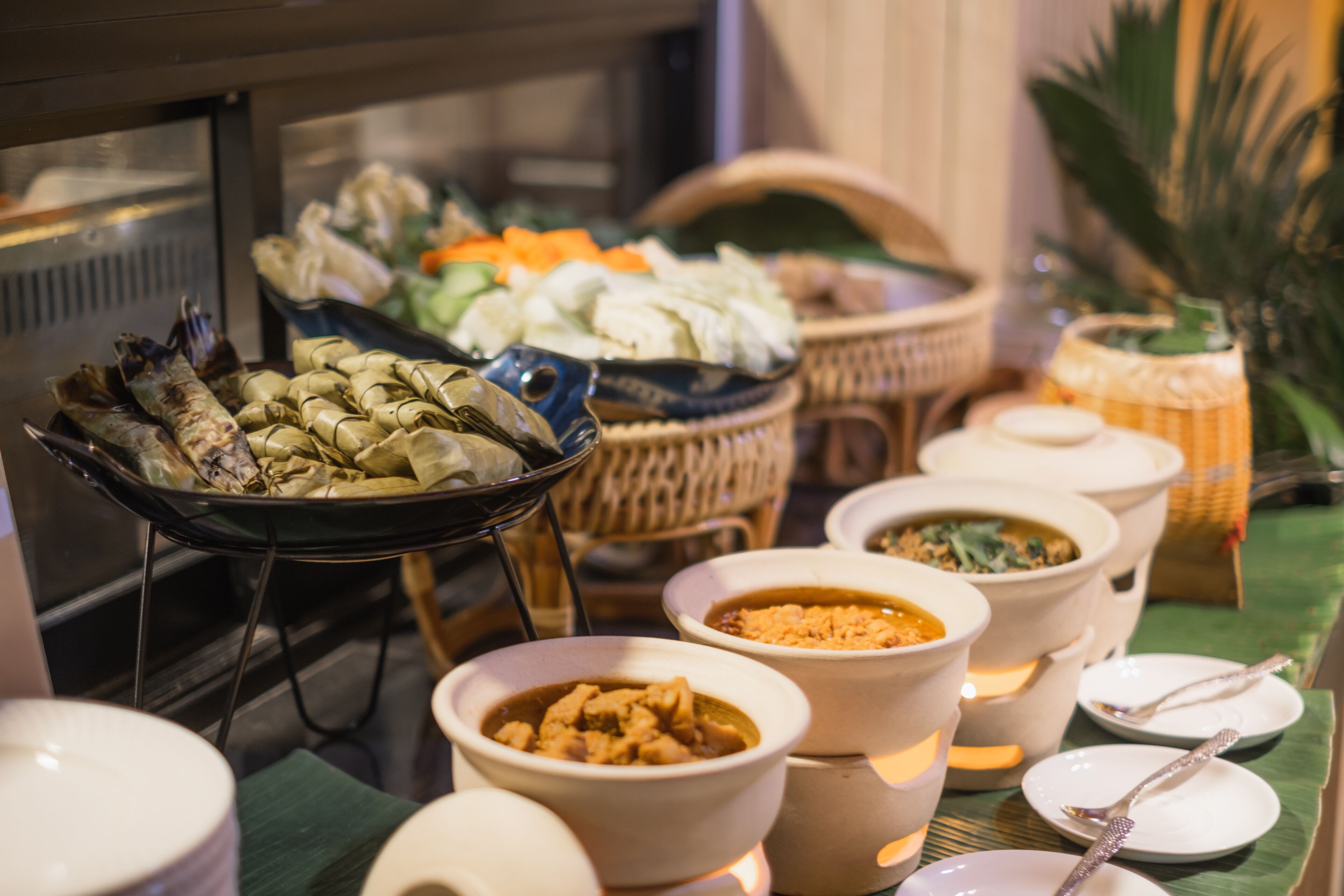 Un buffet proposant une variété de plats, notamment des fruits de mer, des légumes et différents types de soupes.