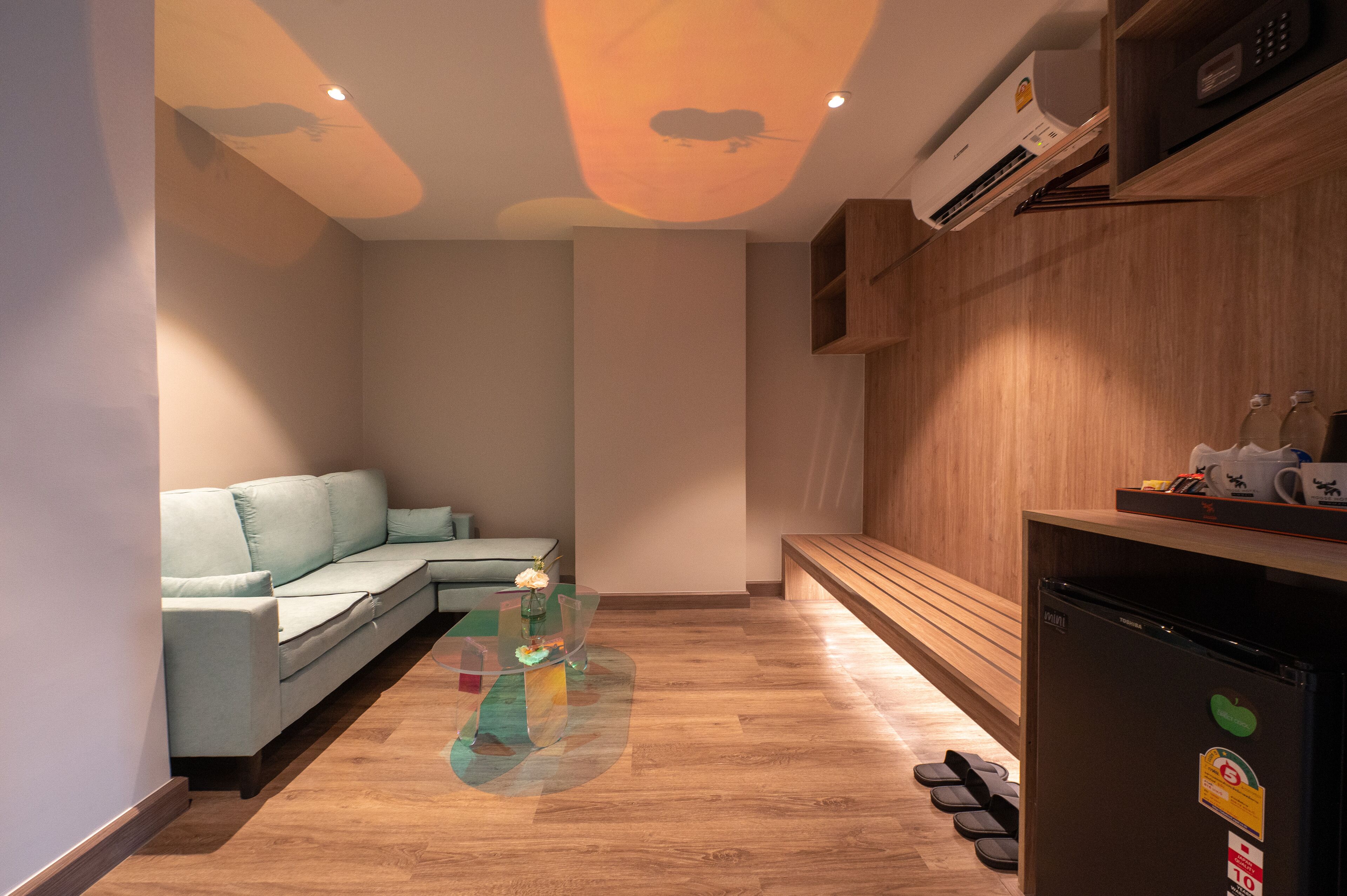 A modern living room with a sectional sofa, a glass coffee table, and a wooden bench.