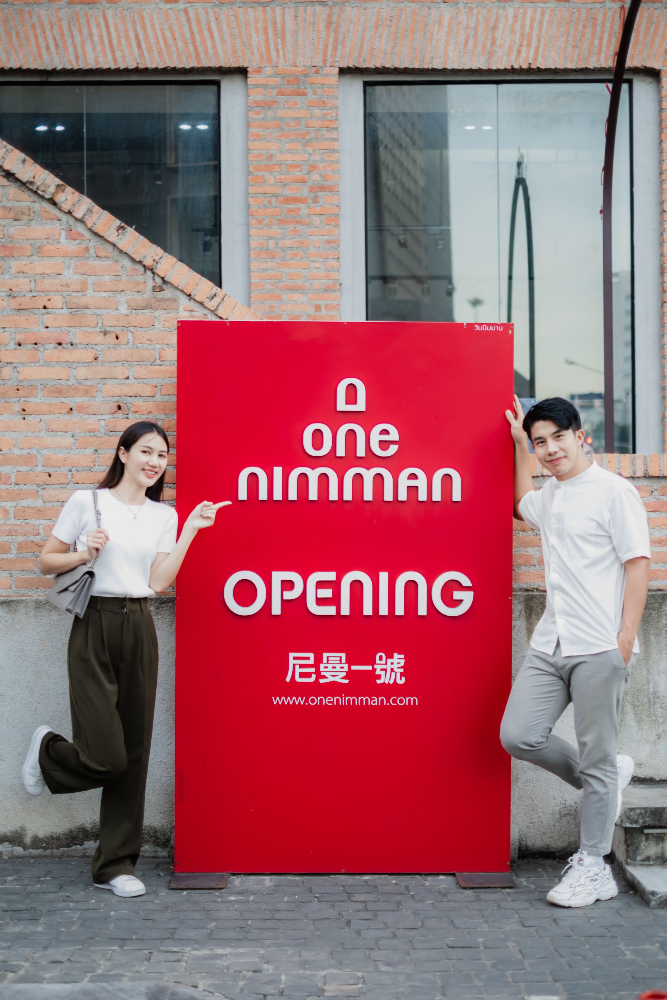A red sign with the text "one niman opening" and a website address.