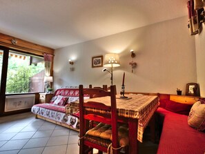 Ein gemütliches Zimmer mit einem Bett, einem Esstisch und einer Couch.