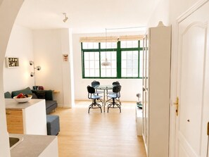 A modern interior with a dining area, a sofa, and a kitchen. - Large quiet terrace. Only 150 m to the sea. (La Caleta)