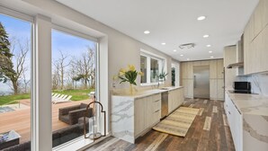 Une cuisine moderne dotée d’une grande fenêtre, offrant une vue sur l’extérieur, et d’un plancher en bois.